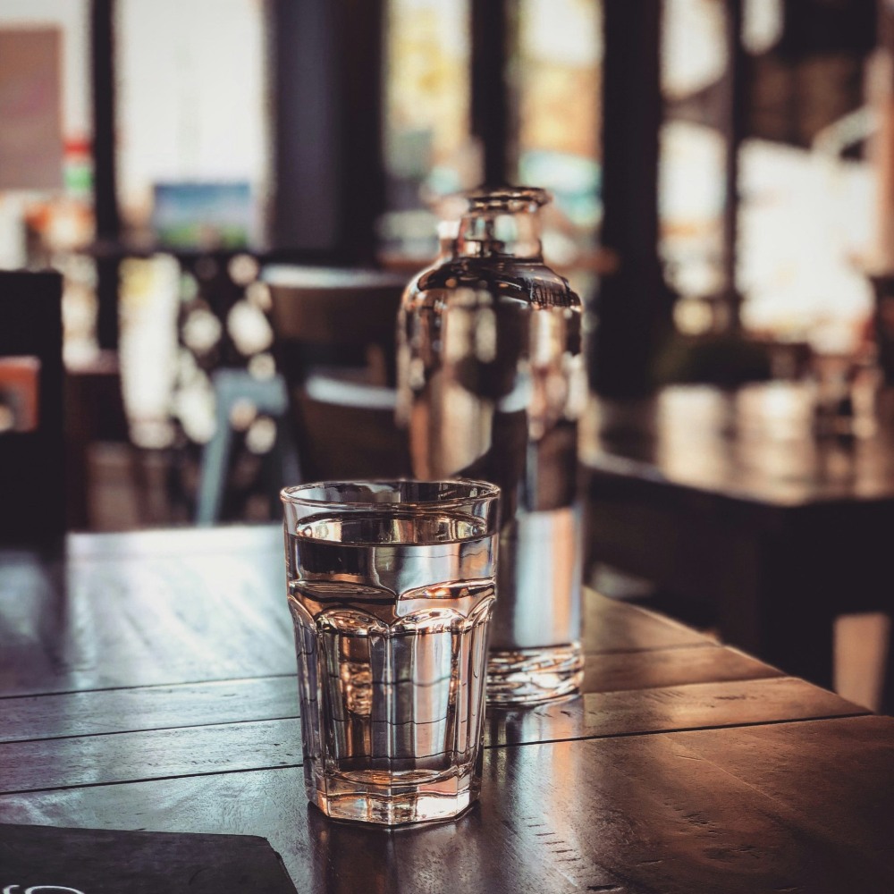 Wasserglas und Karaffe auf Tisch